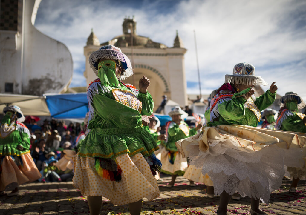 Tänzer in vibranten Kostümen, mitreissende Rhythmen und Küstenkulisse auf Teneriffa im Februar bei perfektem Wetter